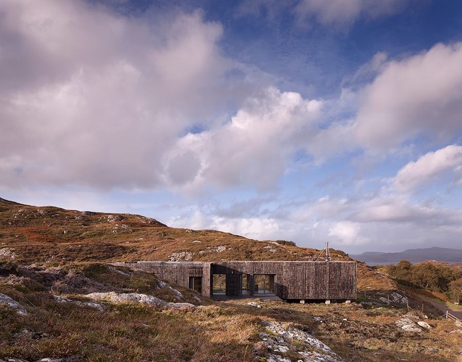 An Cala House blends in with its rugged landscape in Sutherland through its exterior Larch Timber Cladding.