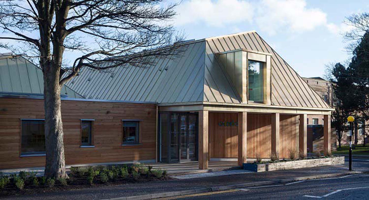 Arcadia Nursery's two-storey building beside a main road. The building has a vertical and horizontal timber cladding and a metal roof.