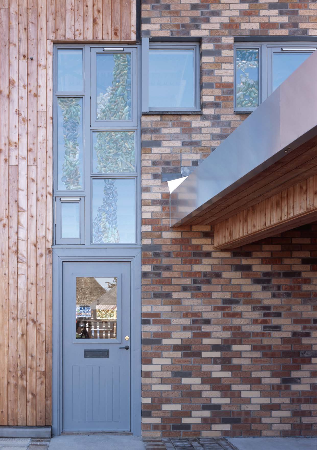 A close up shot of the entrance to the recycling centre showing the variety of materials used in the construction including timber, bricks and steel