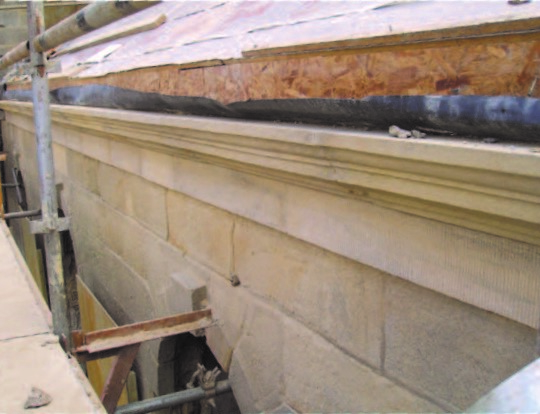 A close up photograph of a sandstone wall being restored