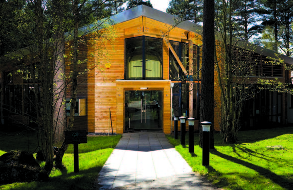 A stone pathway leading to the glass double-door entrance of the Forestry Commission district office. 