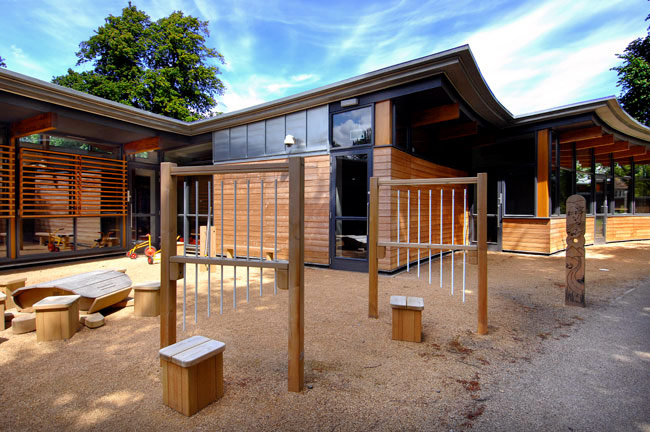 A playground with timber structures and sand on the ground. 