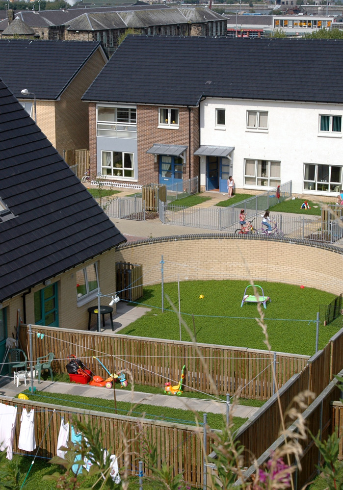 An aerial view of front and back gardens of two-storey houses.