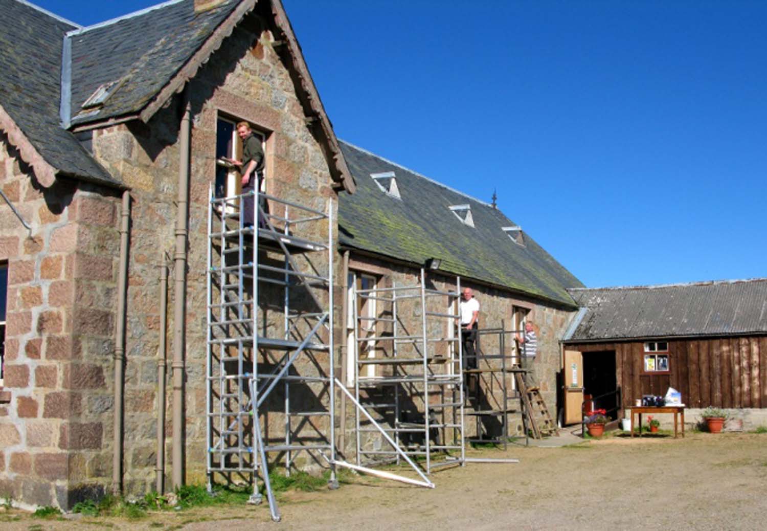 People on scaffolding next to the construction site of the village hall.