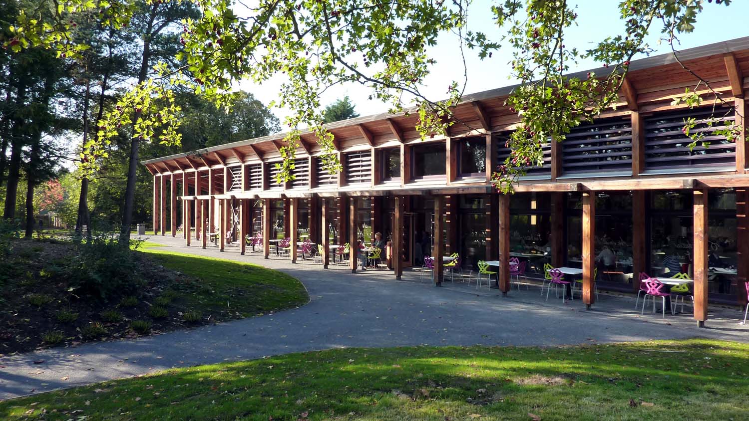 A mum and child sat in the outdoor seating cafe area of the Robert Birthplace Museum set in a park. 