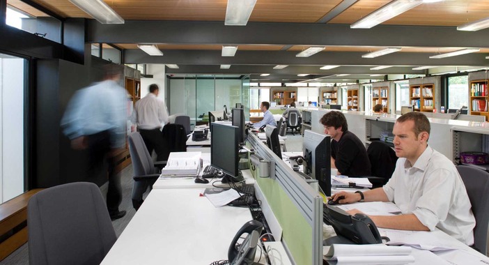 Employees at Scotstoun House using computers in an open-plan workspace. 