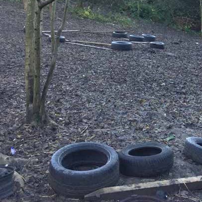 Tyres placed around the forest covered in leaves to form an assault course. An Off Grid Kids Stalled Spaces project.