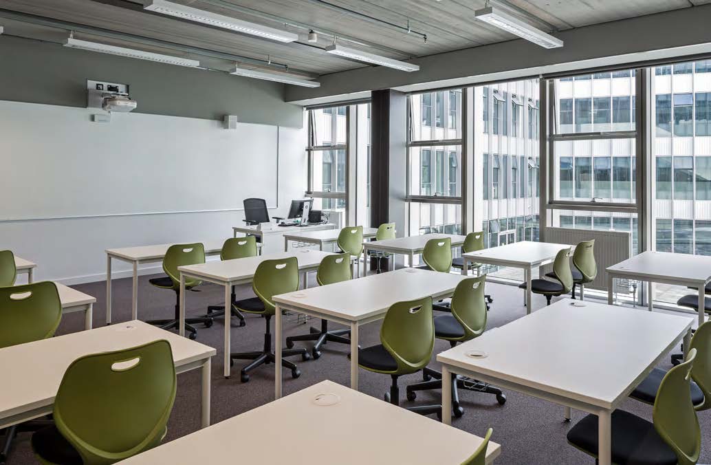 Adaptable classroom space with green moveable chairs and tables at City of Glasgow College.