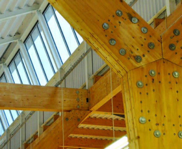A close up of the timber glue-laminated structural frame at Tesco Banchory, with large nuts and bolts holding it together.