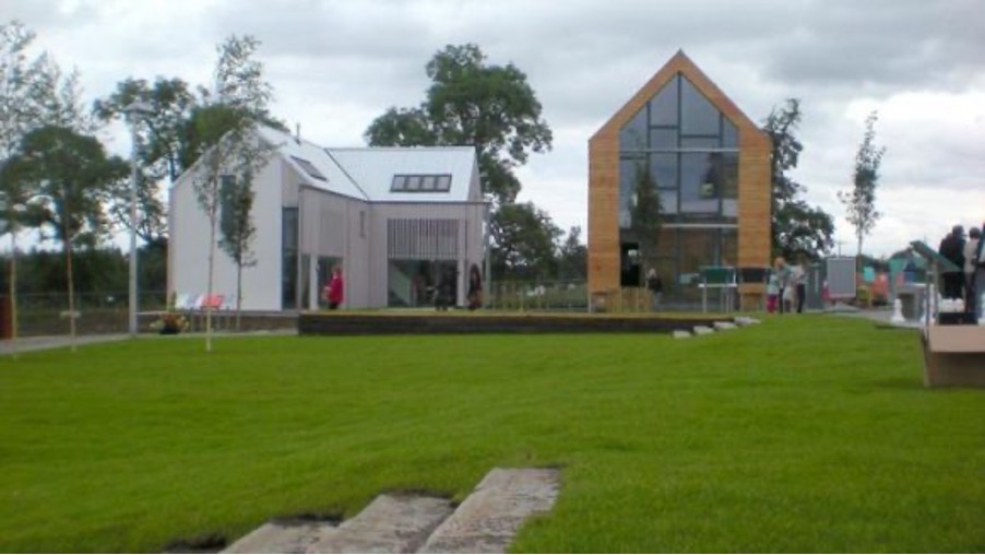 a photograph of two houses side by side - one is white and the other in wood and metal materials