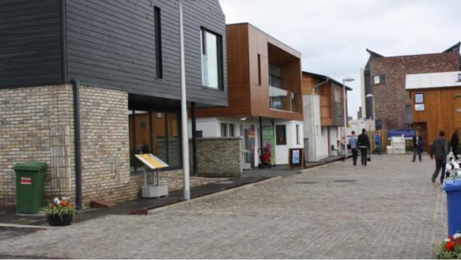 A photograph of a street with houses designed in different architectural styles