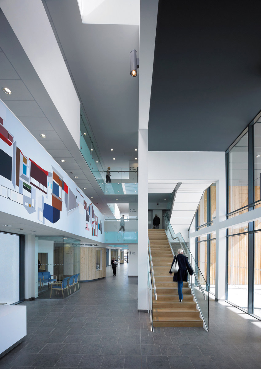 A visitor of Renfrew Health and Social Care Centre walks up main entrance staircase.