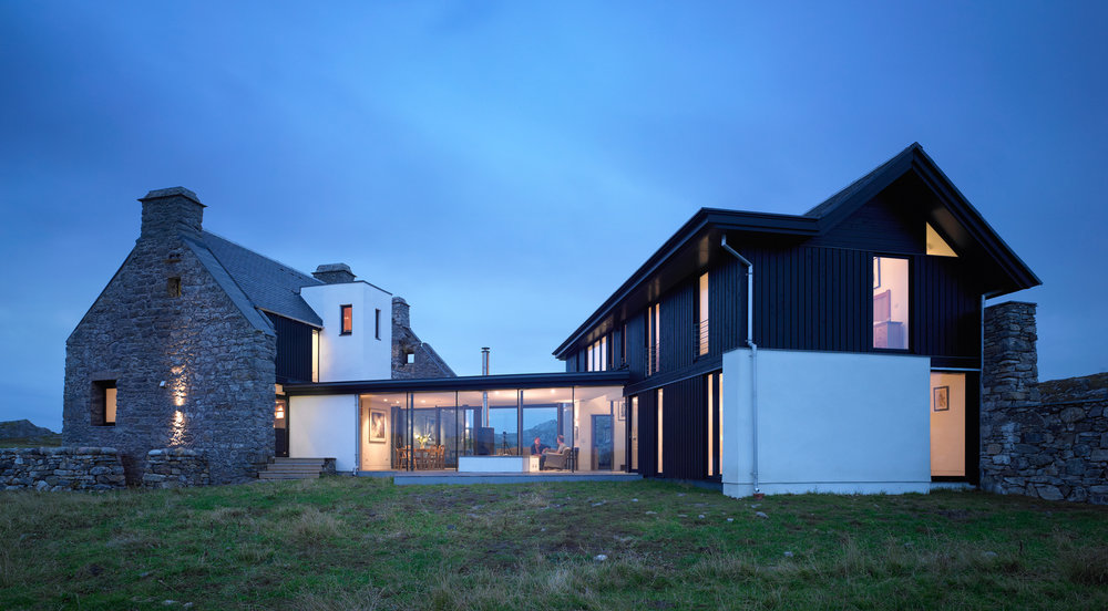 A new single storey glass and timber structure that contains the living room and connects the two buildings.