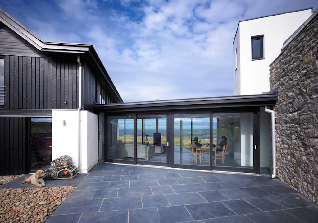 A single storey glass and timber structure connects the two buildings together. The structure contains the living room.