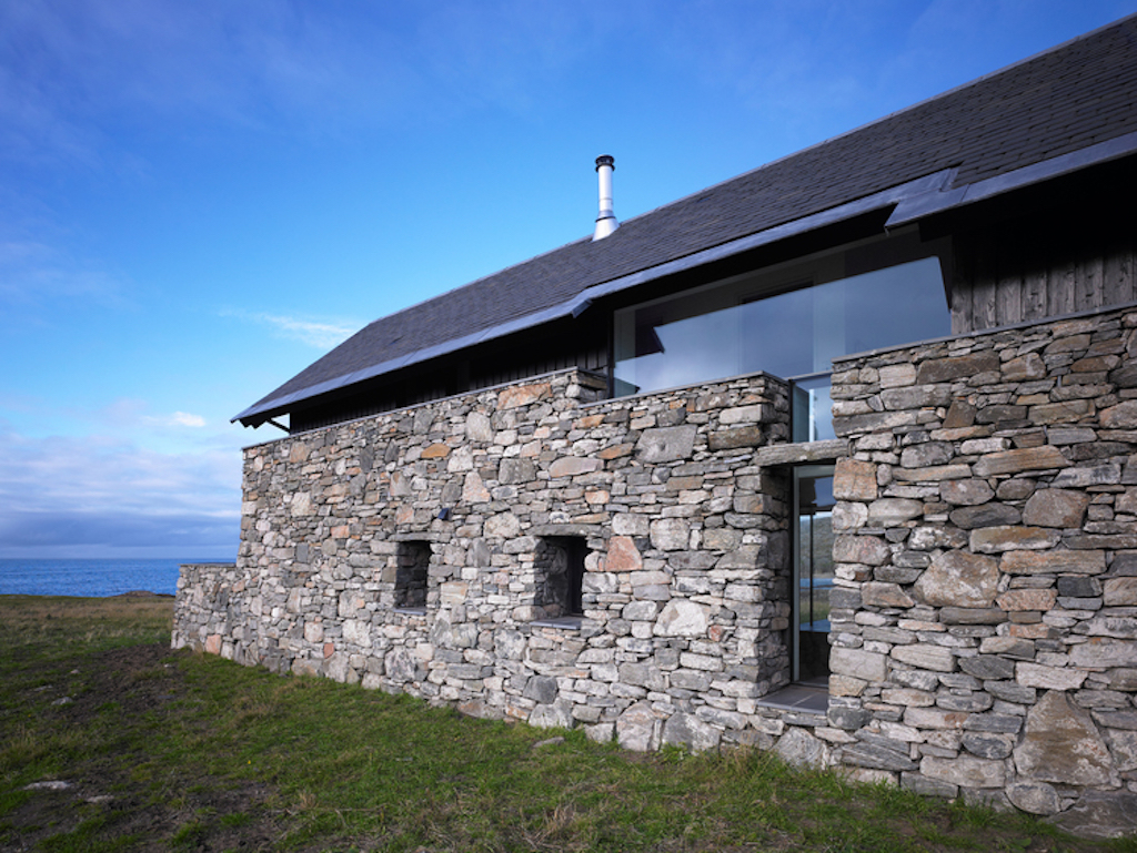 A close-up of the stone wall on of the White House on the Isle of Coll  A large window is seen on the second floor with small windows on the first.