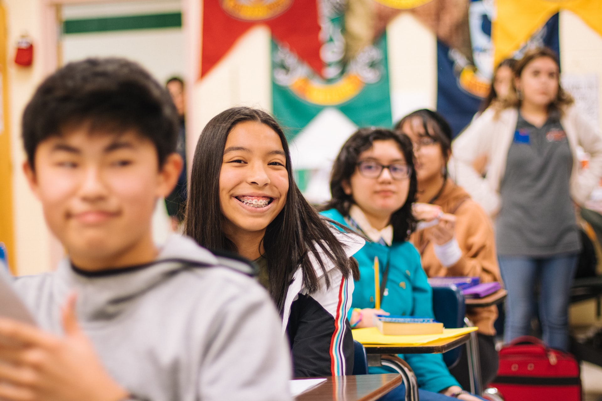 pupils in a class with a young girl smiling at the camera