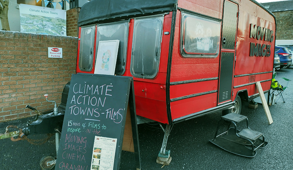 A red cine-caravan and a road sign with the words 'Climate Action Towns-Films'