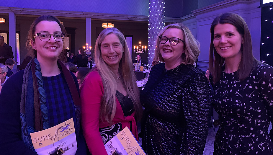 Three members of staff and a board member from Architecture and Design Scotland smiling at the camera at the 2022 SURF Awards.