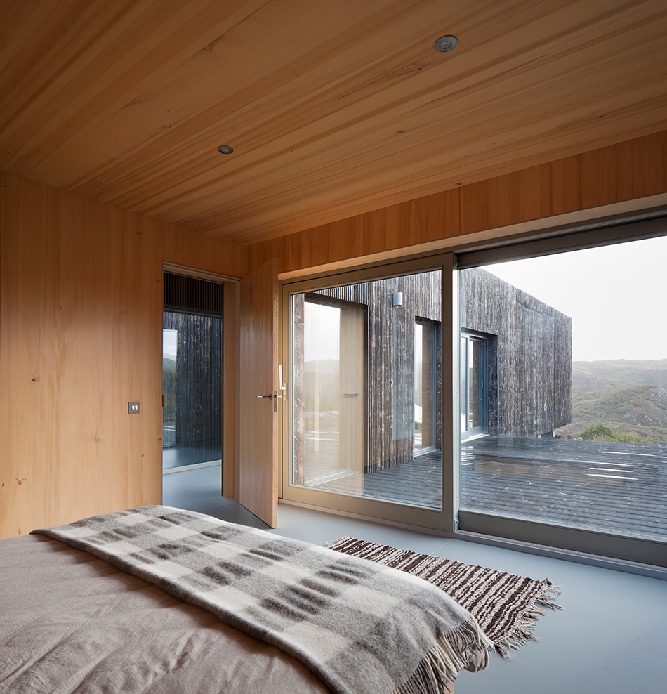 Master bedroom at An Cala house with floor to ceiling sliding doors that lead to an outdoor patio.