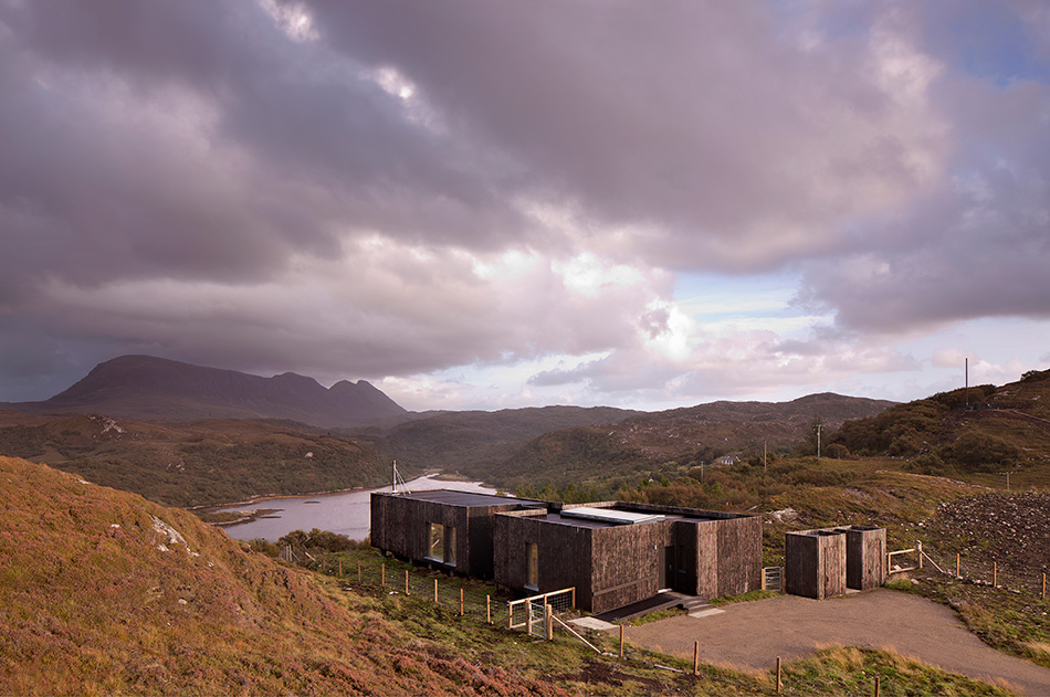 An Cala House nestled in between two hills and overlooking Loch Nedd and Quinaig below.