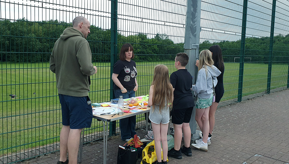 Climate Action Towns project team speaking to children in an outdoor space during their visit to Holytown.