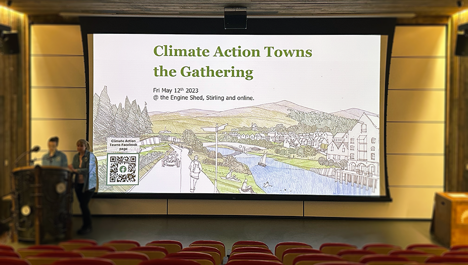 An auditorium with the Climate Action Towns presentation on the big screen. 