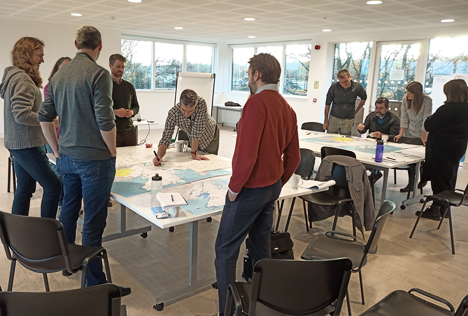 People from the Highland Council discussing around a map on a table.