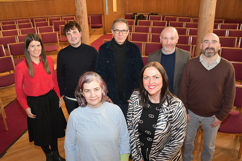 Seven people from the project team for the Town Centre Living and Investment Roadshow looking up at a camera and smiling