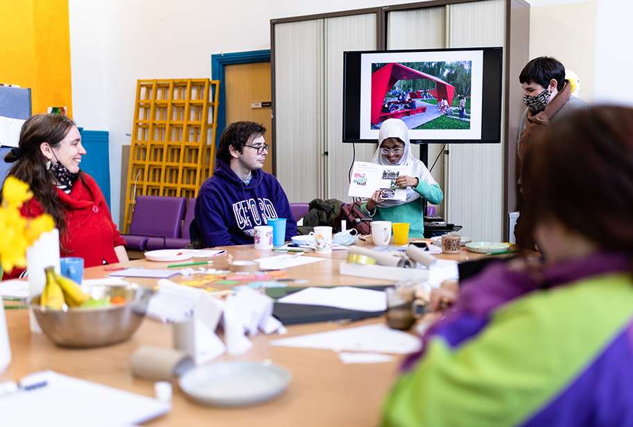 A young person presenting her ideas of a pavilion to her community and designers.