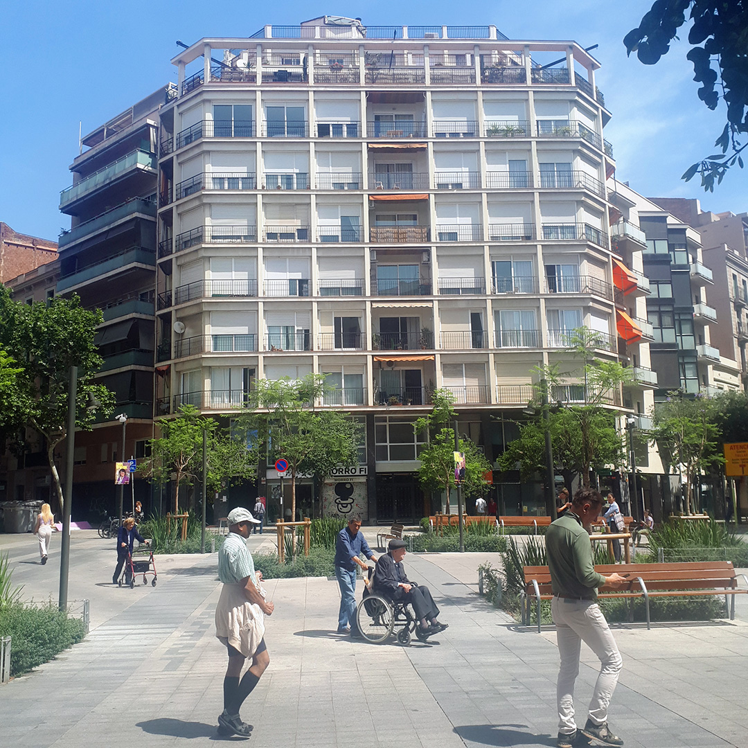 Locals walking through a square amidst Barcelona's Superblocks.