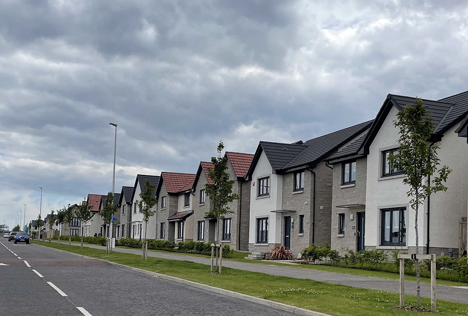 A housing development by the side of a road.