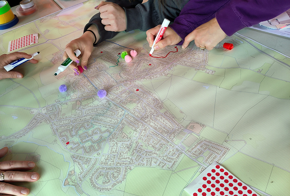 People drawing on top of a map with sticky dots to map out key areas in Armadale.