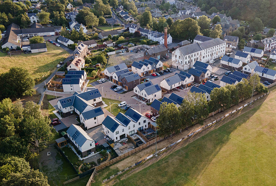 An aerial view of Housing at Caerlee Mill, Innerleithen with trees and green spaces.