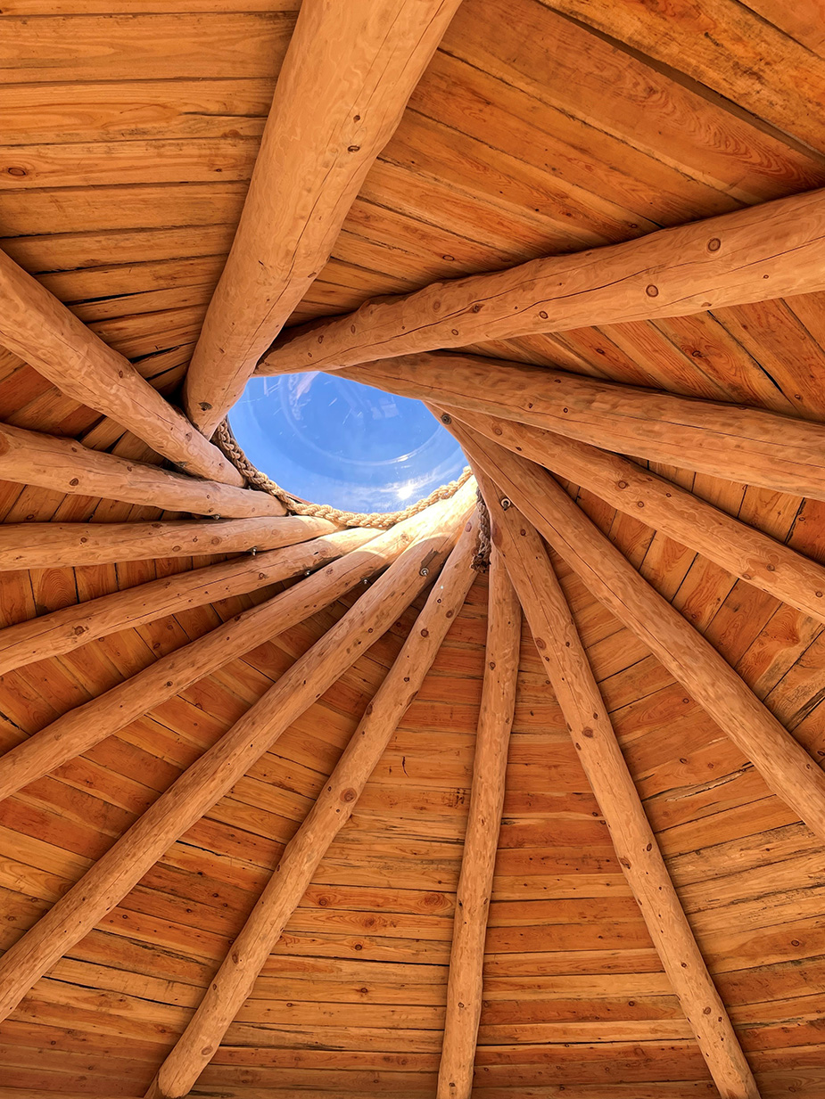 A view from inside The Howff showcasing its circular wooden beams converging towards a domed central skylight.