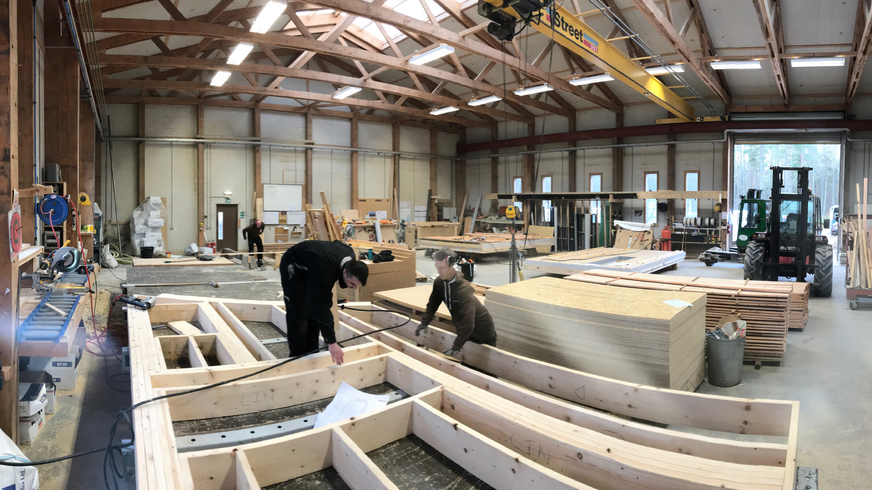 People builting wall panels in a factory.