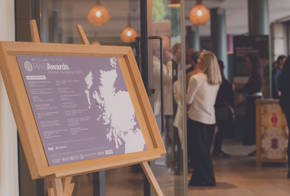 A poster of the RIAS awards with people milling in the background.