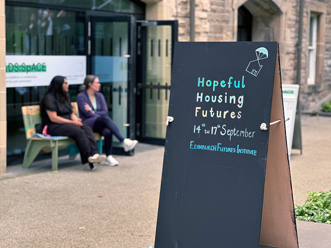 A chalkboard sign with the words "Hopeful Housing Futures; 14 - 15 September; Edinburgh Futures Institute"