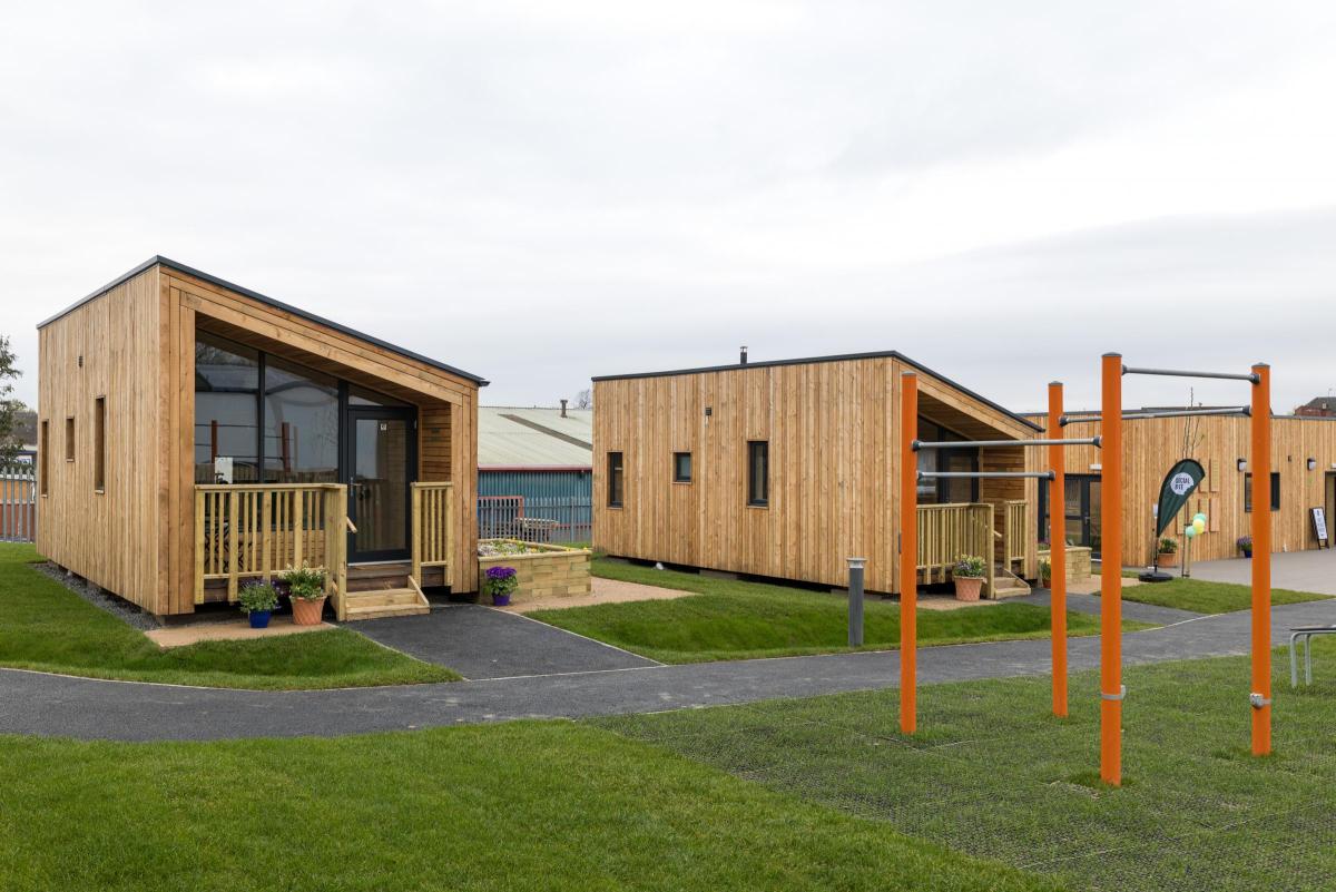 Mono pitched roofed affordable housing with timber cladding.
