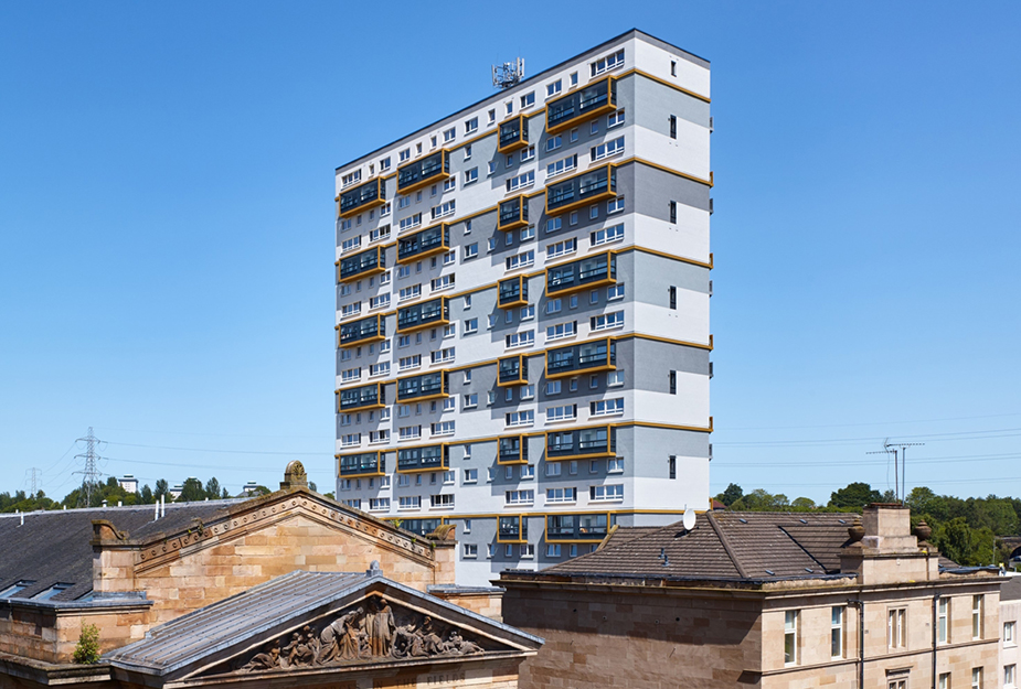 A grey multi-story building with yellow lines surrounding the balcony.