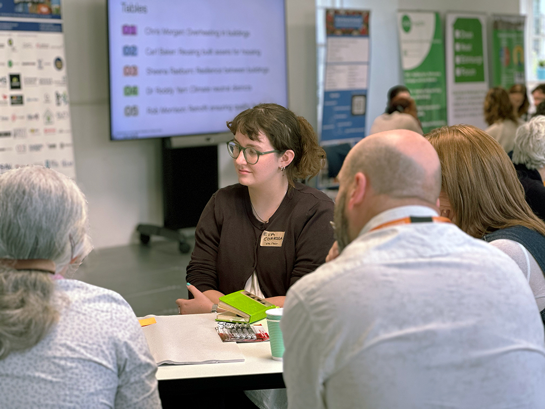 Event attendee at one of the group tables at the Climate Clinic listening to a speaker.